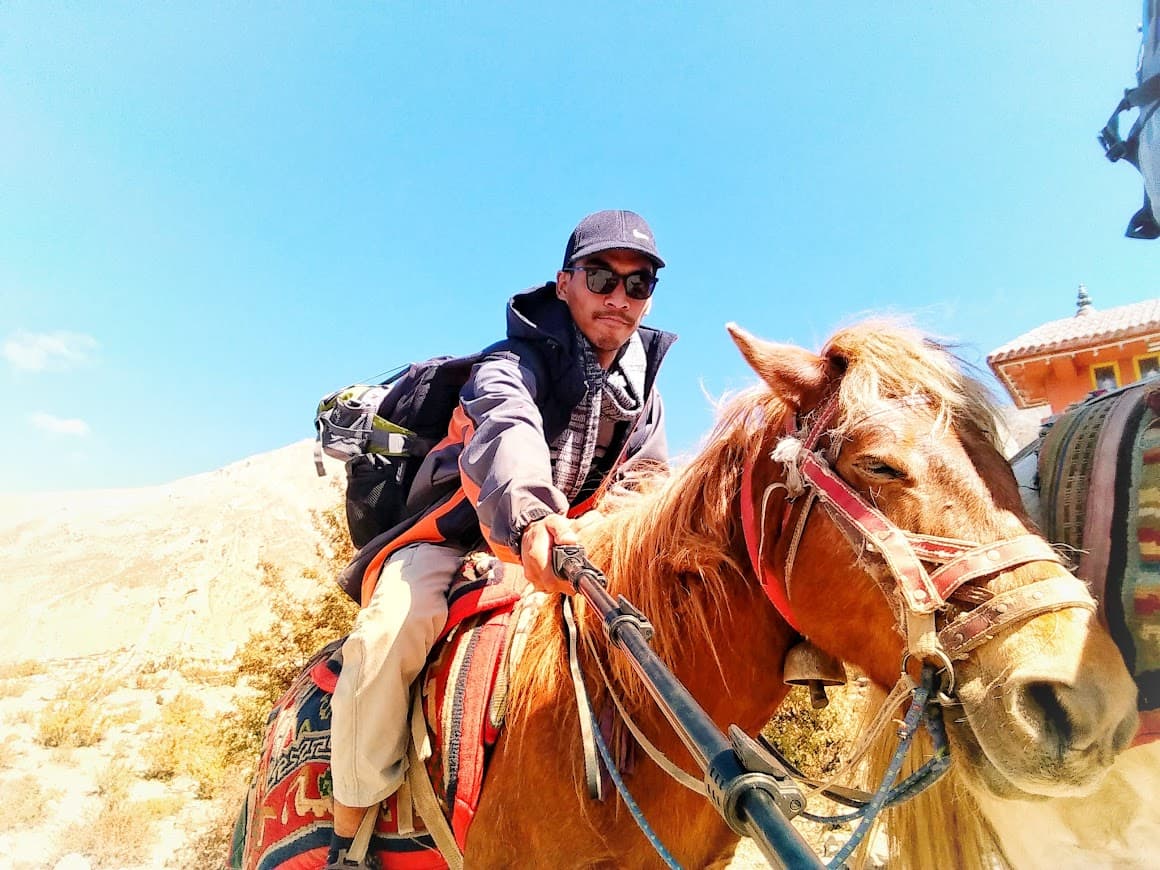 Milan travelling on horseback through a mountain landscape